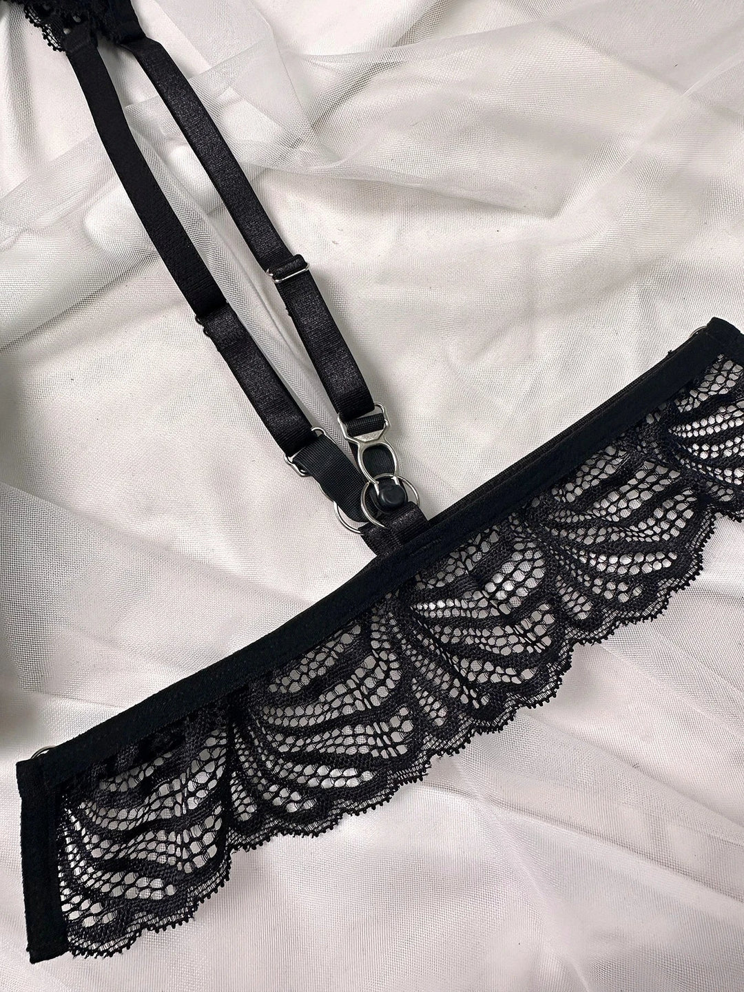 Elegant black lace lingerie set with strappy bra, garter belt and thong with floral details